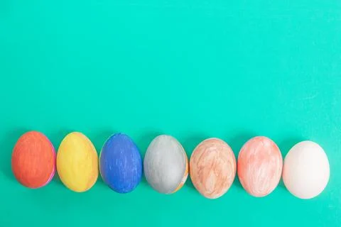 Row of colorfully painted Easter eggs on a bright color background. Stock Photos