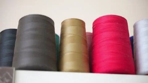Row of colourful cotton thread spools on shelf in tailor workshop, reels of Stock-Footage 246974372