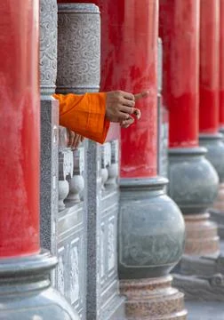 Row of columns in a Buddhist temple with the hands of a monk Stock Photos