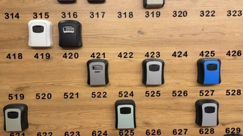 Row of combination lock boxes on a wooden wall display for secure key stora.. Stock Footage 336208423