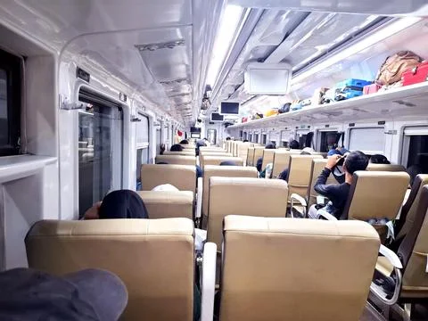 Row of comfortable passenger seats inside executive class train coach durin.. Stock Photos