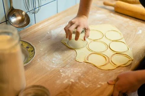 Row of cut dough circles on kitchen table photo Foto stock