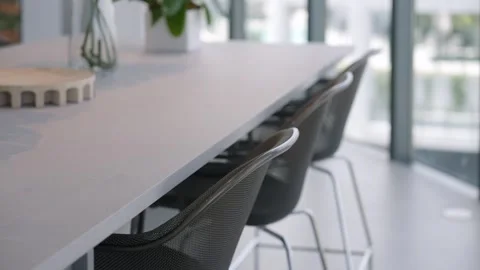 Row of dark chairs made of fine mesh standing by long rectangular table Stock Footage 282283989