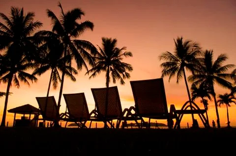 Row deckchairs on beach at sunset, Stock Photos