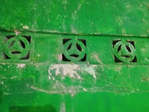 Row of decorative ventilation breeze blocks on an old green painted wall. Stock Photos