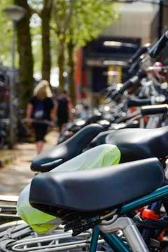 A row different bicycles parked outside in the parking lot close to the main Stock Photos