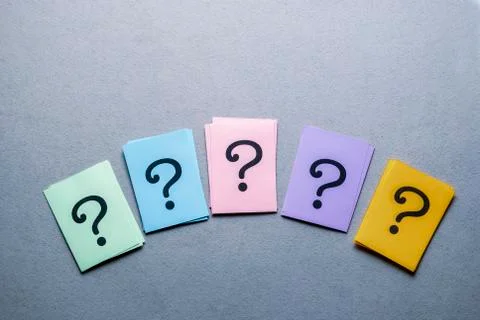 Row of different colored cards with question marks Foto stock