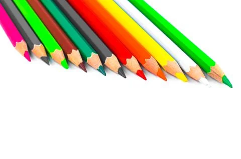 Row of different colored pencil crayon placed on top of a bright white colore Stock Photos
