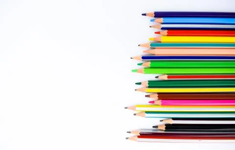 A row of different colored pencil crayons facing sideways on a white backgrou Stock Photos