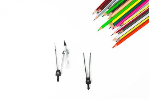 A row of different colored pencil crayons pointing at two pencil compass Stock Photos