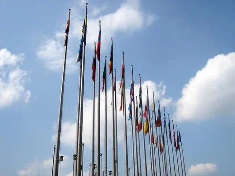 A row of different national flags of countries on flagpoles in perspective Stock Photos
