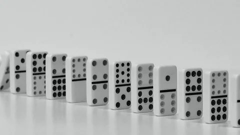 Row of Dominoes Falling in Slow Motion in Black and White Stock Footage 83696345