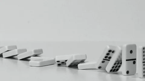 Row of Dominoes Falling in Slow Motion in Black and White Stock Footage 83696354