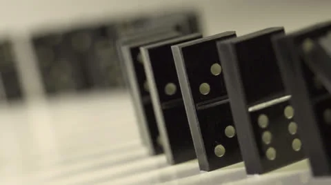 Row of dominoes with one falling over Stock Footage