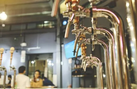 Row of draft beer taps at a bar. Beer taps in a row in perspective. Close up of Stock Photos