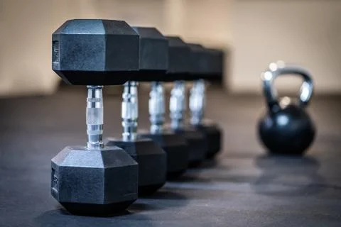 Row of dumbbell exercise weights on the floor Stock Photos