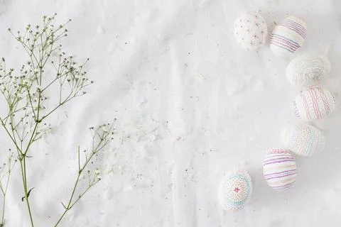 Row easter eggs with patterns near plant twig feathers textile Foto stock