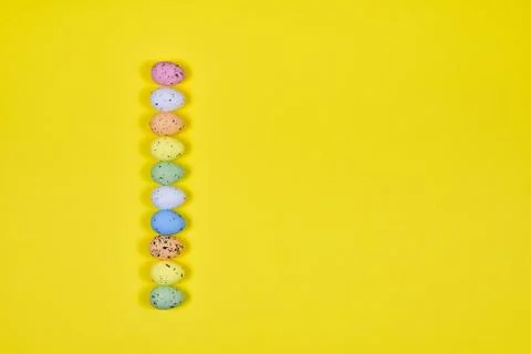 A row of Easter eggs on a yellow background. Easter concept. View from above Stock Photos