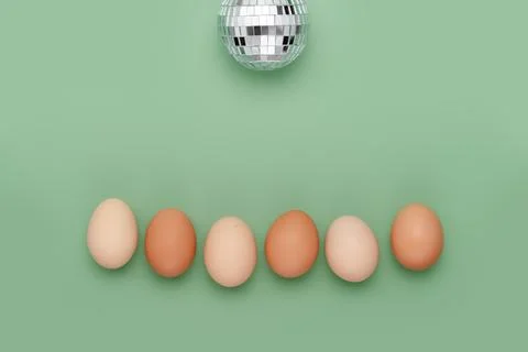 Row of eggs under disco ball. Fun Easter background Stock Photos