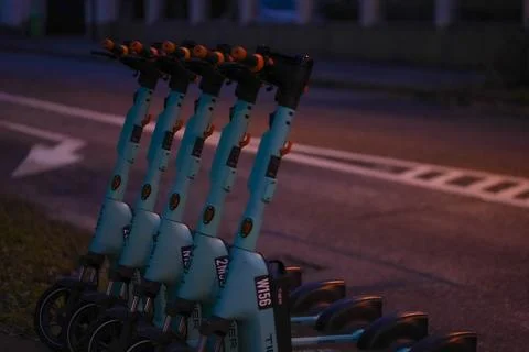 Row of electric rollers lined up to rent in the evening Stock Photos