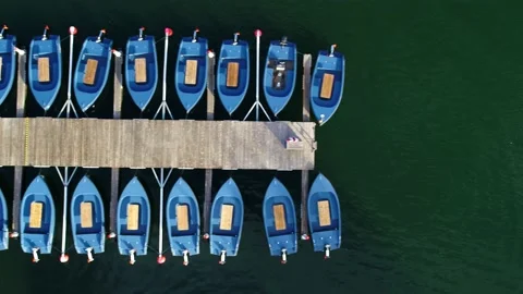 Row of electrical dinghy tied to a bridge aerial video Stock Footage 235449775