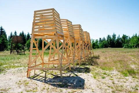 Row of elevated wooden observation platforms with ladders in open field, mo.. Foto stock