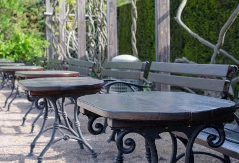 A row of empty benches and tables outside Stock Photos
