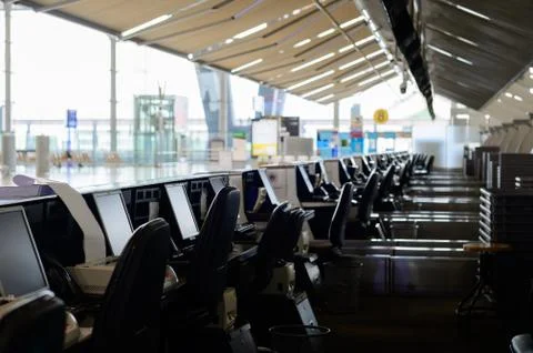 Row of empty check-in desks with computer monitors at the airport Stock Photos