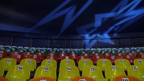 A row of empty colorful chairs in a circus or a performance with flashing lights Stock Footage 308471103