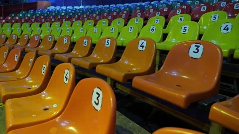 A row of empty colorful chairs in a circus or a performance with flashing lights Stock Footage 308471236