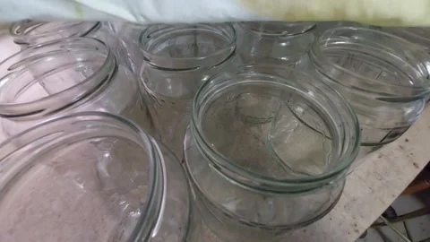 Row of empty glass jars on a workshop counter being covered with a cloth Stock Footage 335826689