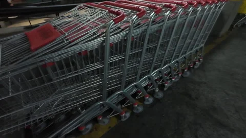 Row of empty metal shopping carts in an underground parking lot Stock Footage 345183064