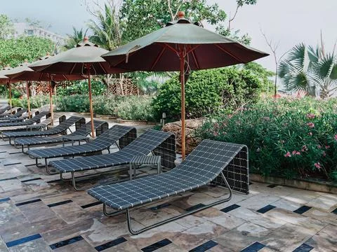 Row of Empty Poolside Benches and Umbrellas at Resort Foto stock