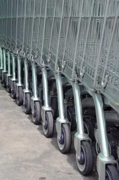 Row of empty shopping carts in big supermarket Stock Photos
