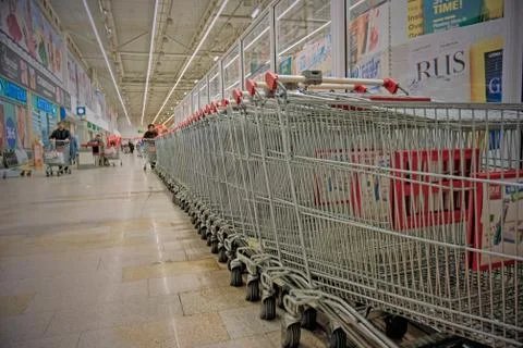Row of empty shopping carts in the big supermarket Stock Photos