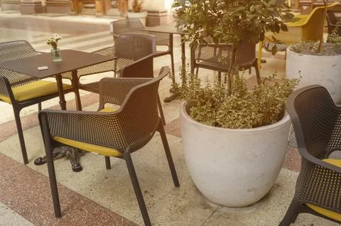 Row of empty tables in an outdoor restaurant patio with organized seating 库存照片