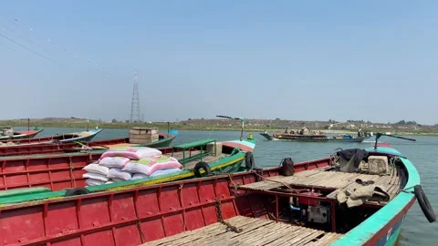 Row of empty trawler boats docked in Asian port with engine boat arriving on Stock Footage 346464389