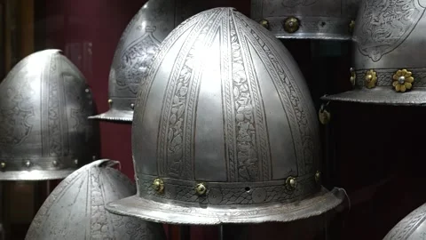 Row of engraved comb morion helmets palace armoury grand master's palace Stock Footage 341772804