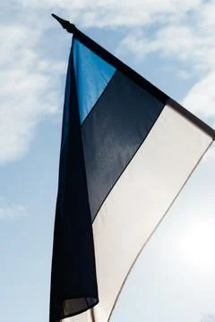 A row of Estonian flags waves in the winter sun, decorating a historic Stock Photos