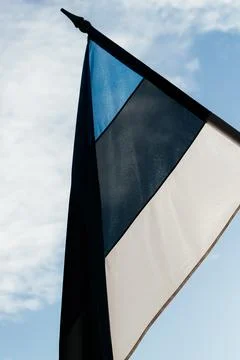 A row of Estonian flags waves in the winter sun, decorating a historic Stock Photos