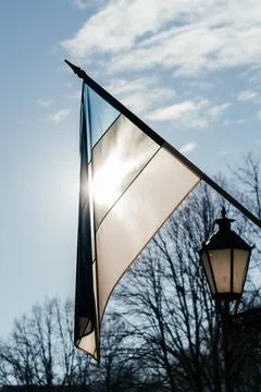 A row of Estonian flags waves in the winter sun, decorating a historic Stock Photos