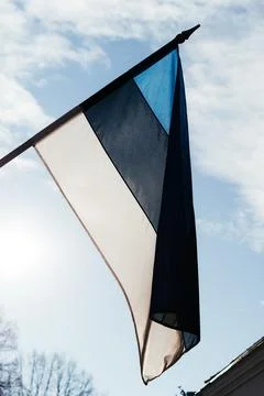 A row of Estonian flags waves in the winter sun, decorating a historic Stock Photos