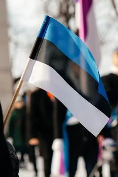 A row of Estonian flags waves in the winter sun, decorating a historic Stock Photos