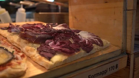 A row of flatbread pizzas in the showcase table in front of the restaurant Stock Footage 129928024