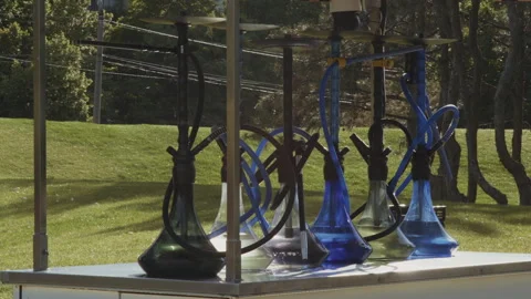A row of glass hookahs stand on the counter of a street bar in the park Stock Footage 341436532