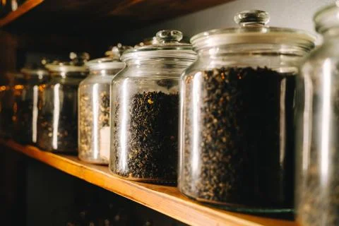 Row of glass jars with different types of tea on a shelf Foto stock