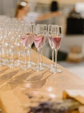 Row of glasses filled with champagne are lined up ready to be served in weddi Stock Photos