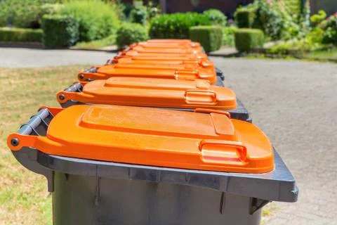 Row of gray garbage containers along the street Stock Photos