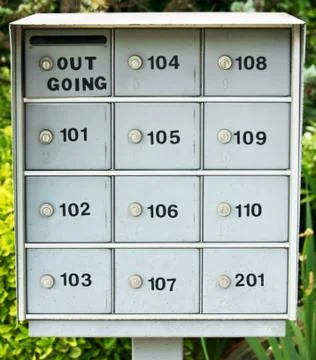 A row of gray mailboxes outside an apartment complex 스톡 사진