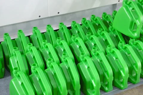 Row of green empty plastic containers standing in a row in a manufacturing pl Stock Photos